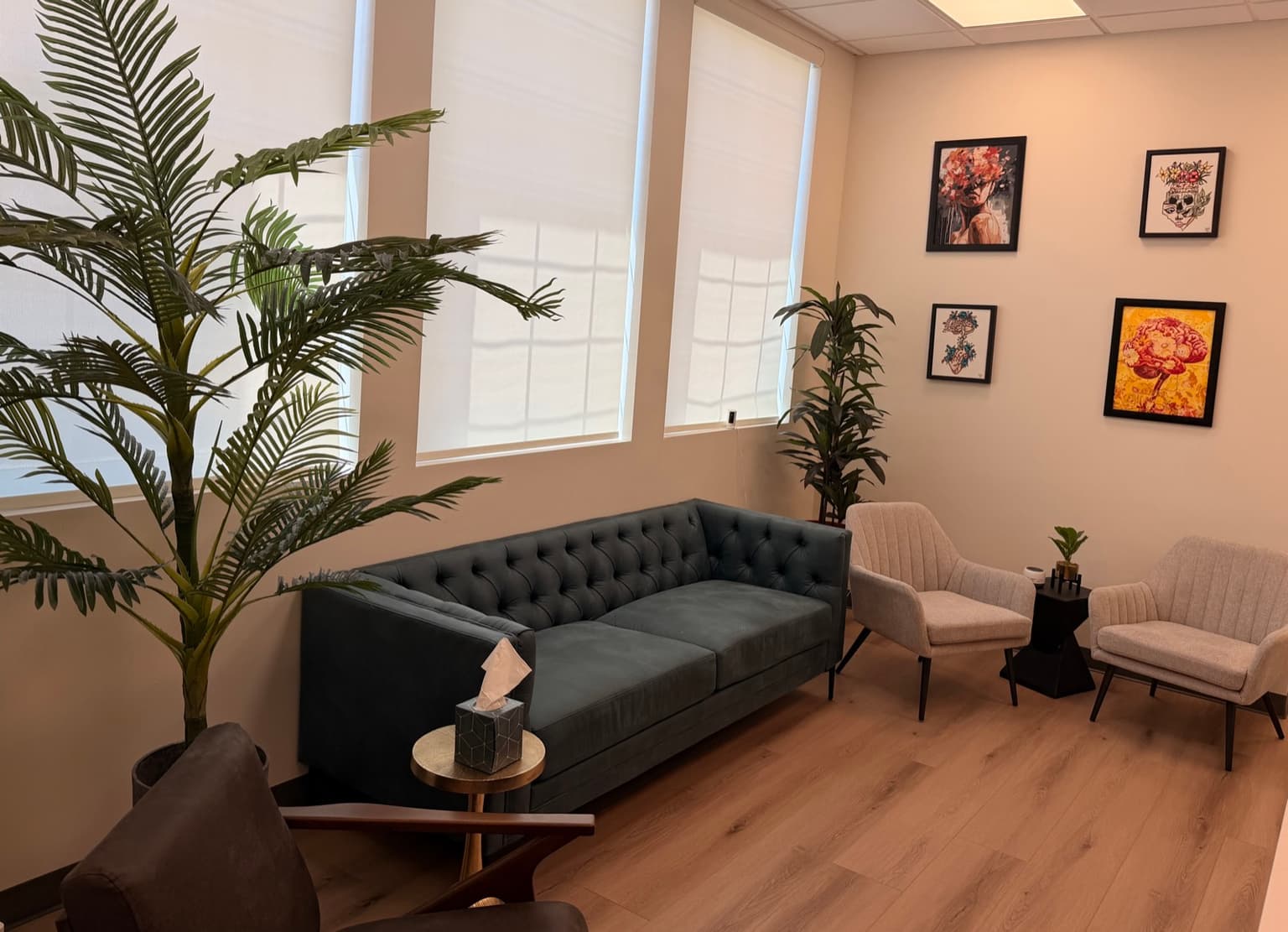 Private psychiatry room with tufted sofa and mental health artwork at Crescent Health Clinic, South Jordan, Utah